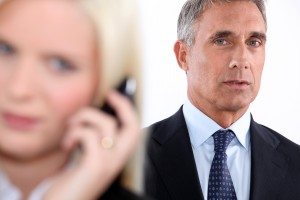 Man looking on as a woman takes a phone call