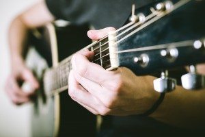 close up of hands playing guitar