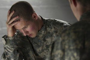 Emotional military man consoled by peer, horizontal