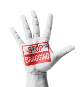 Open hand raised, Stop Bragging sign painted