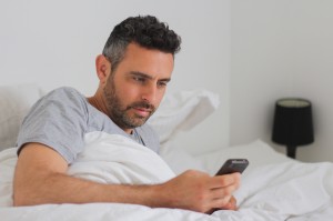 men in bed use his smartphone