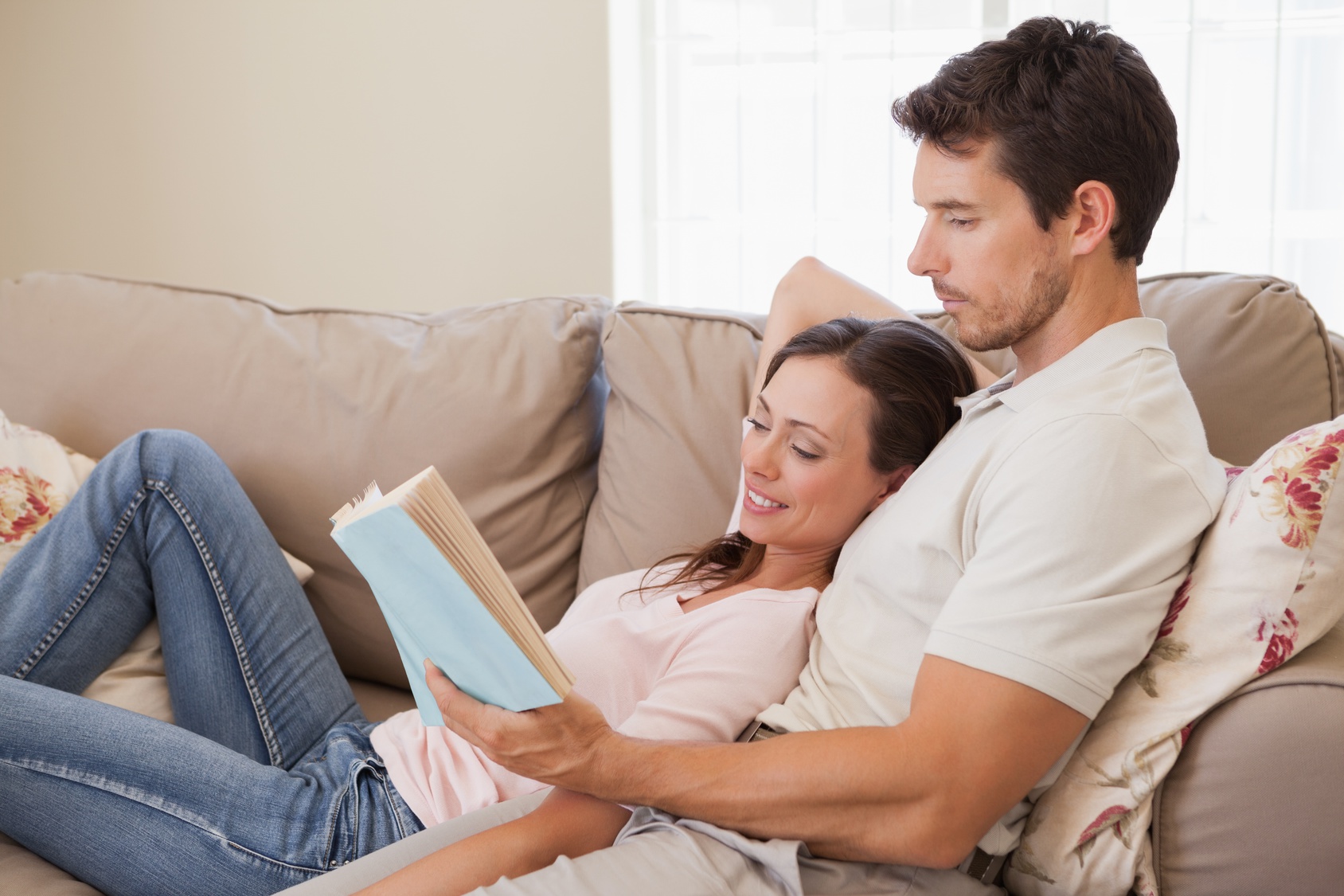 Русский муж жена на диван. Девушка с парнем на двинае. Парень и девушка на диване. Пара читает книгу. Диван для чтения.