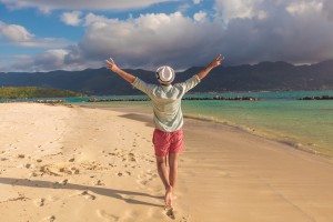 man walking on the beach and celebrates his joyous life