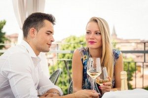 Attractive casual young couple drinking a glass of wine in a hot