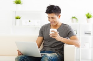 happy young Man sitting in sofa and using  laptop