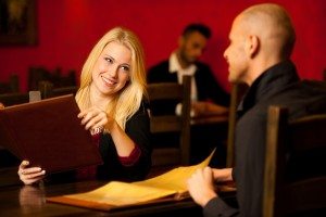 Young couple ordeting food in restaurant reading menu