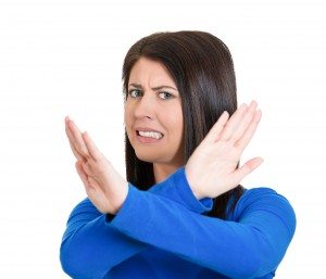 angry young woman with X gesture to stop talking, cut it out