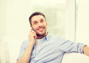 smiling man with smartphone at home