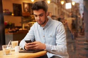 Man Viewed Through Window Of Caf‚ Using Mobile Phone