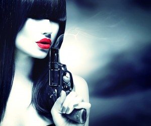 Sexy model woman with a gun. Black and white portrait