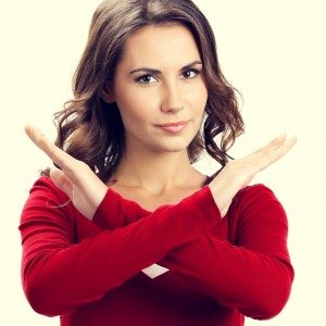 Portrait of serious woman showing stop or reject gesture