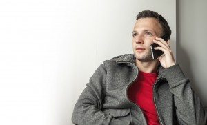 Portrait of young adult Caucasian man talking on mobile phone