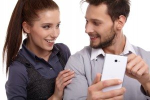 Attractive couple taking a selfie together on white background