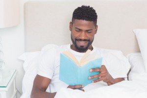 Handsome man reading in bed