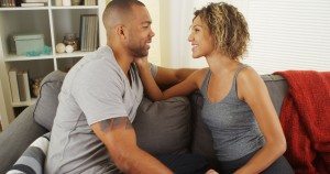 Affectionate african couple talking on couch