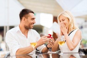 happy couple with engagement ring and wine at cafe