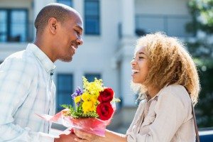 Young man gives flowers to girlfriend