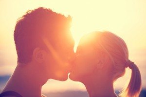 Young couple kissing each other at sunset.